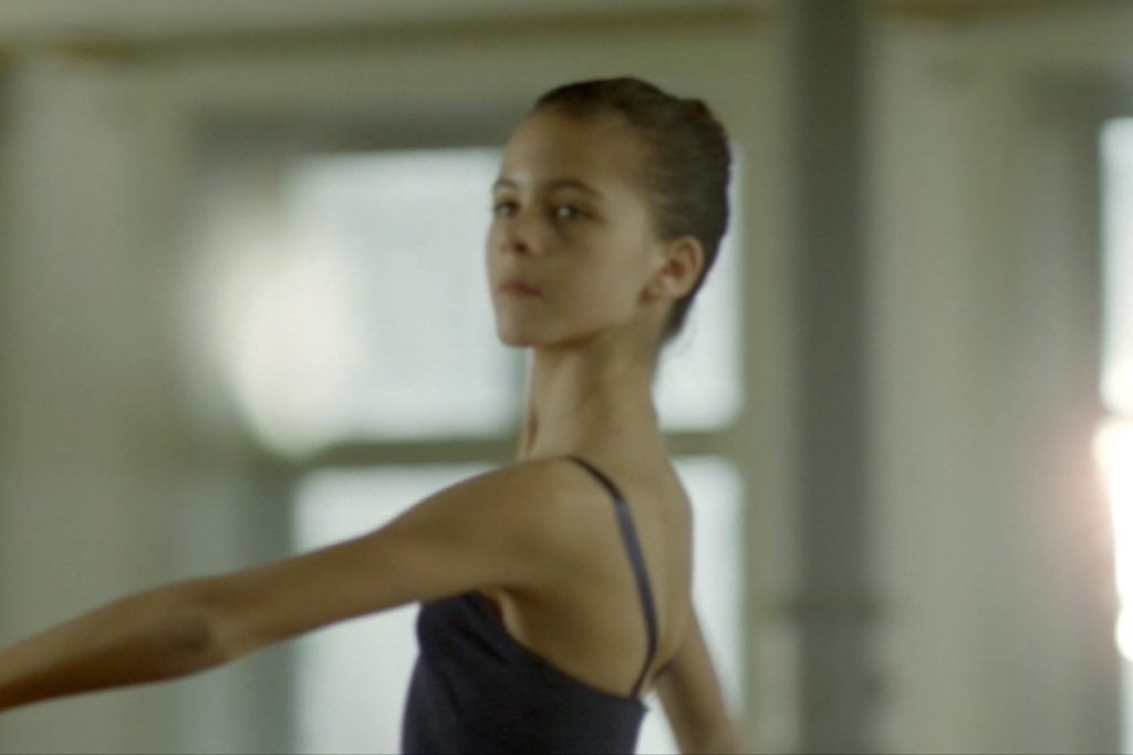 Eine junge Ballerina setzt zu einer Pirouette an.